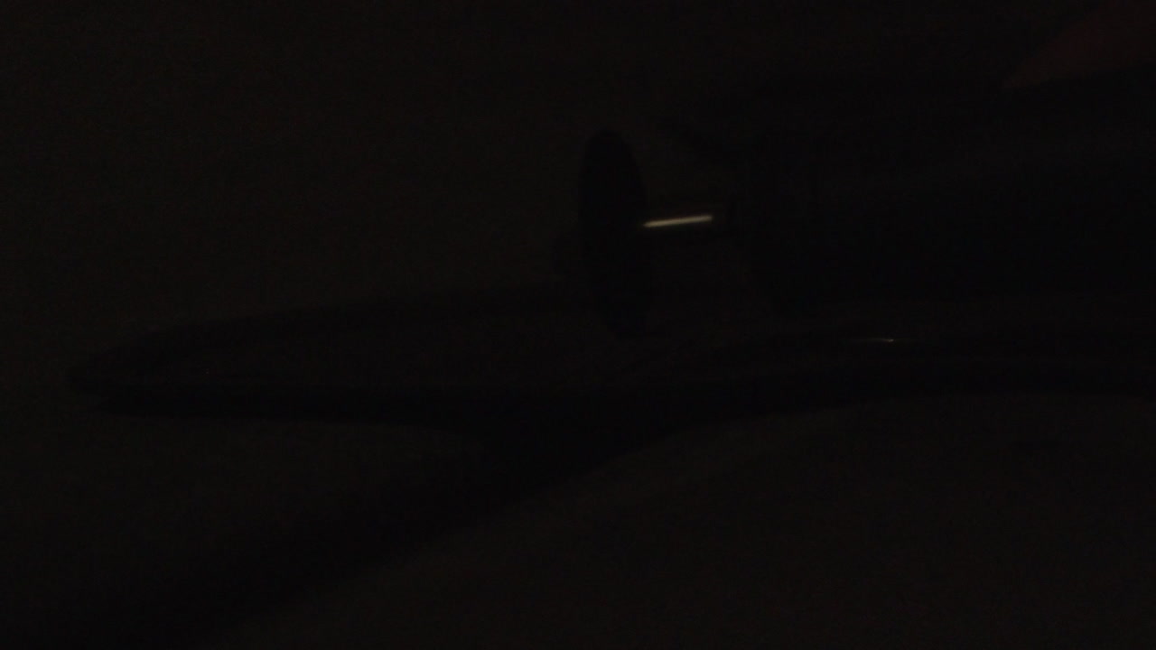 искры летят в замедленной съемке в темном гараже, когда вращающийся инструмент разрезает металл