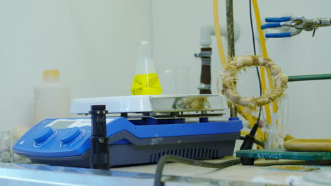 laboratory equipment and yellow liquid in a flask on a heating plate