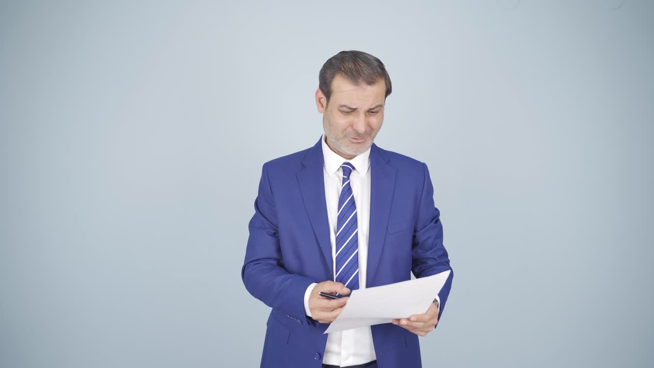 el hombre de negocios examina el papeleo y se enoja.