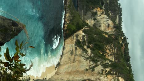 vertical static shot overlooking diamond beach on nusa penida bali from the top of the cliff on a slightly overcast day with the wind blowing