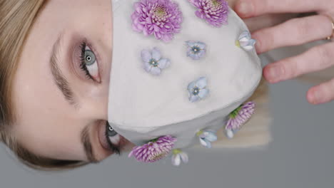 vertical portrait of woman in face mask decorated with flowers