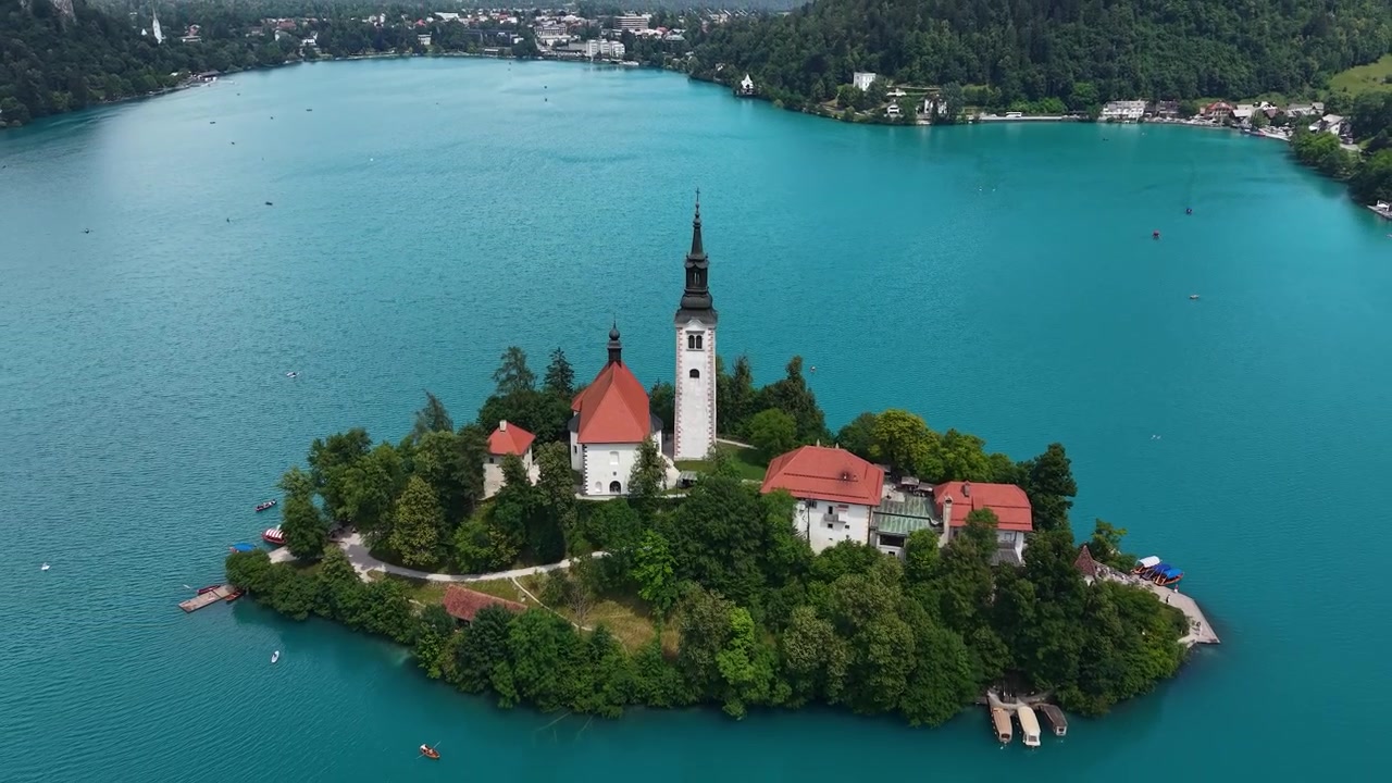 Lago di Bled, Slovenia. Ripresa con drone di chiesa cattolica e torre su piccola isola in acqua alpina turchese