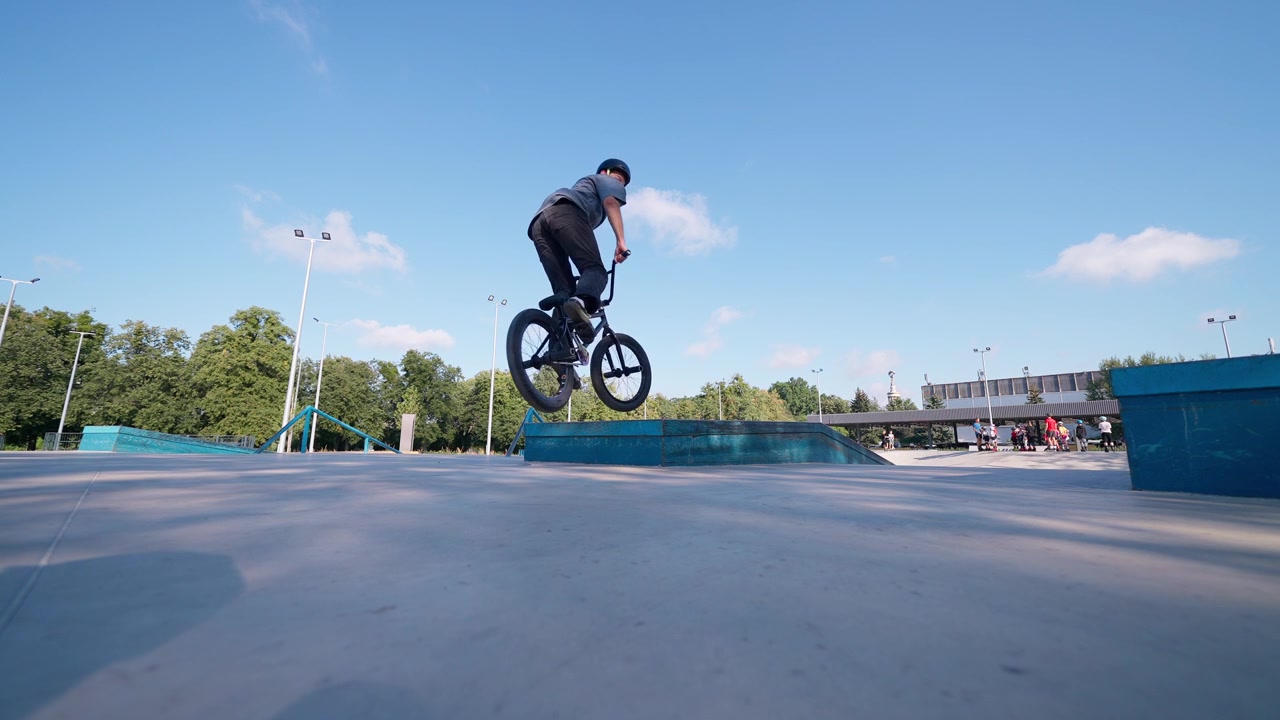 Giovane uomo che esegue un trick con la bici BMX in uno skatepark