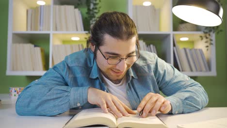 un joven alegre sueña despierto mientras lee un libro.