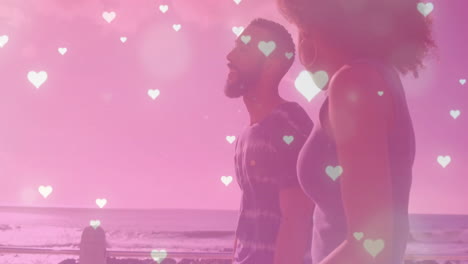animation of hearts falling over biracial couple walking at seaside