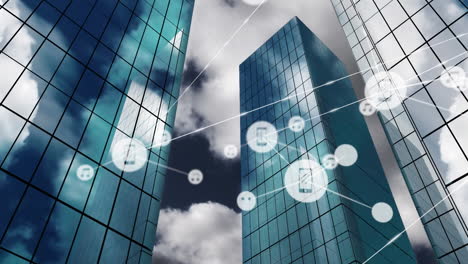 animation of network of digital icons against low angle view of tall buildings and blue sky