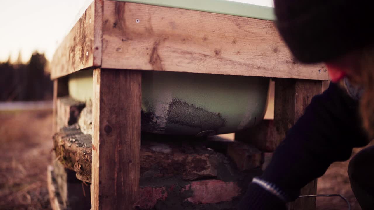 그 남자는 뜨거운 욕조 에 벽돌을 시멘트하고 있습니다.