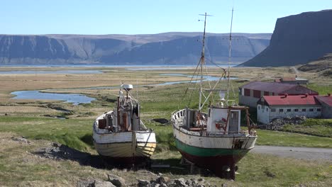 abandoned fishing boats sit on the land in a remote fjord in iceland as the cod industry declines 2