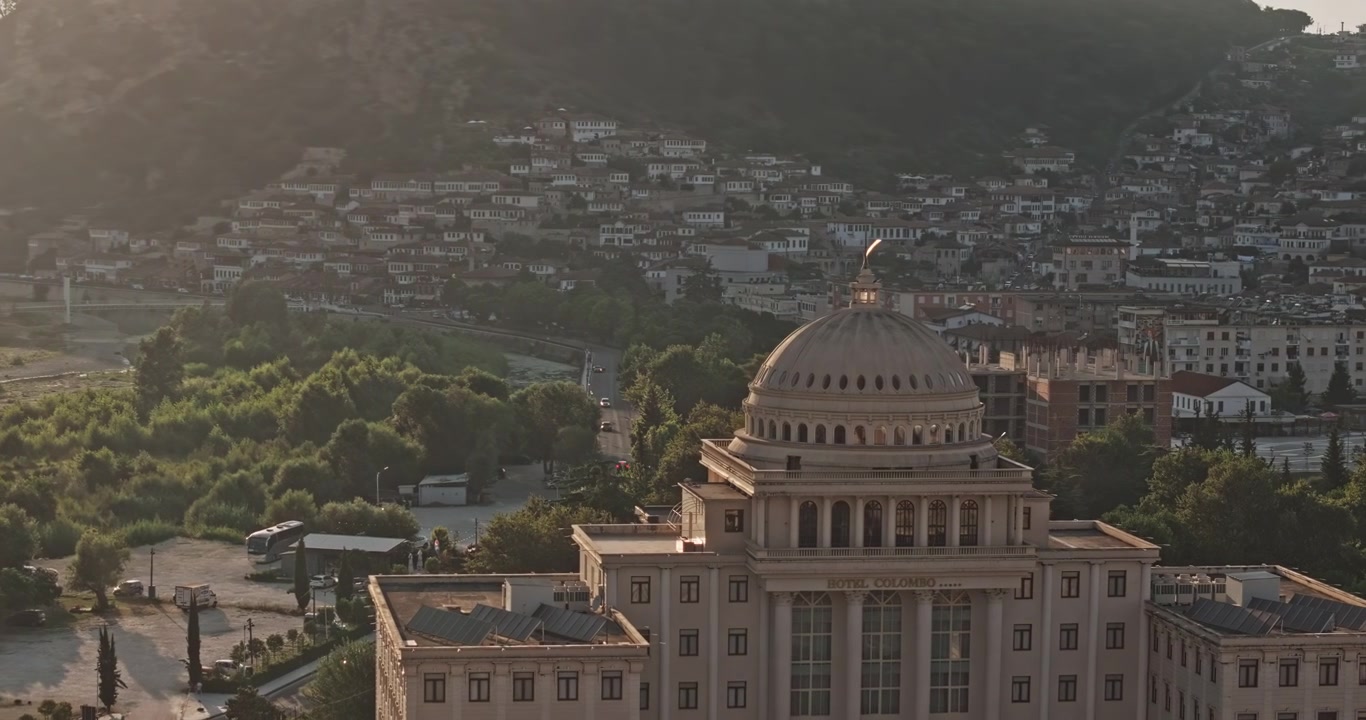 Berat Albania Aerea v17 sorvolo a bassa quota con zoom 3x verso l'Hotel Colombo, catturando residenze del centro, il paesaggio urbano e la collina del castello al tramonto - Ripreso con Mavic 3 Pro Cine - 11 luglio 2024