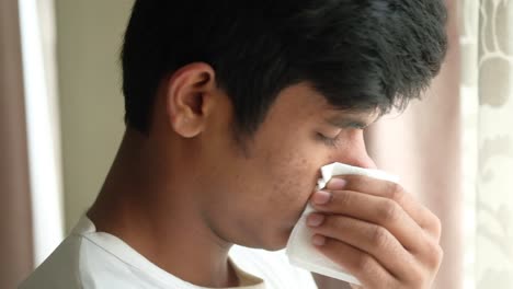 young man blowing nose