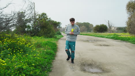 Man In The Nature Walking With Yellow Flowers In The Hand