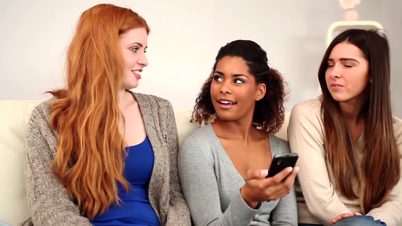 Gorgeous friends having a conversation sitting in bright living room