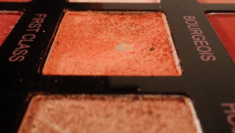 close-up of makeup palette with eyeshadows and brush