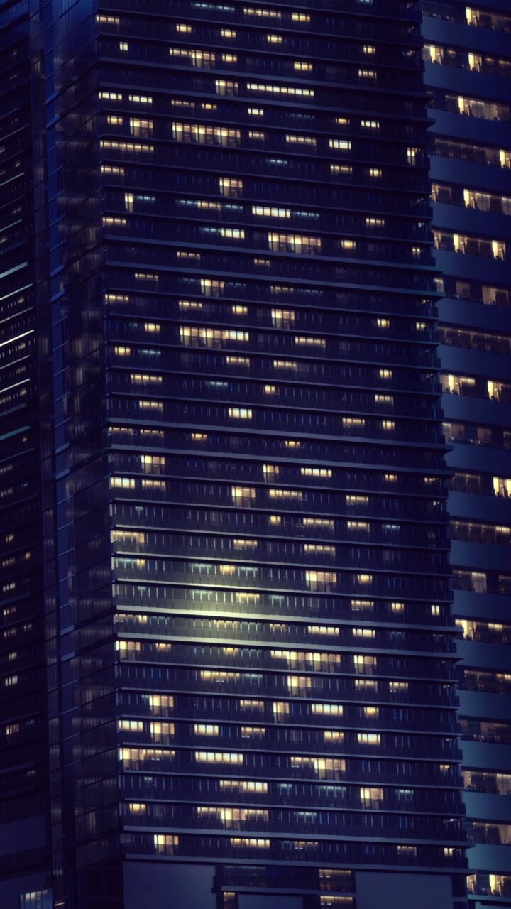 City skyline with illuminated buildings at night during evening hours