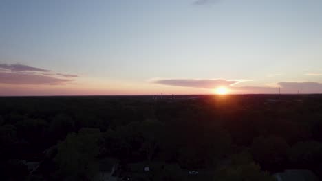 A-drone-shot-of-a-small-downtown-at-the-time-of-sunset-in-orange-sky-background