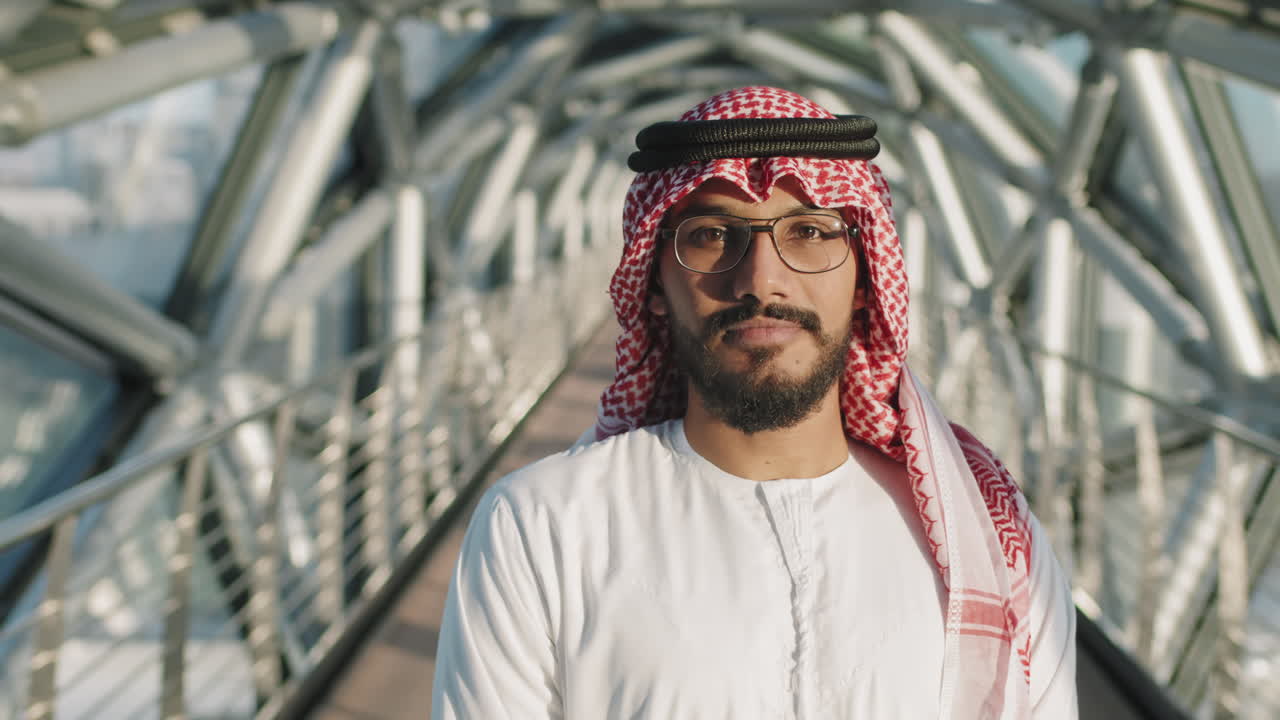 retrato del joven jeque de pie en el puente de vidrio