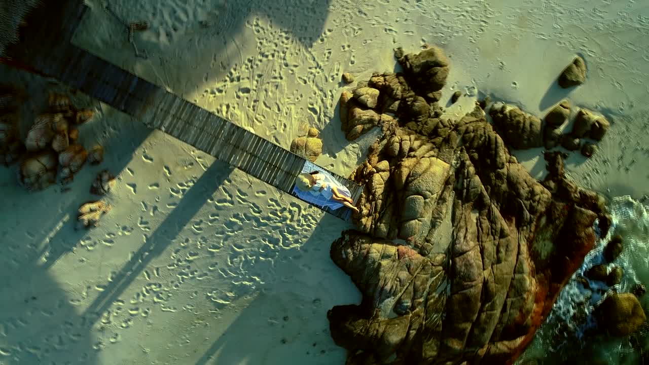 은 나무 다리 해변에서 잠을 자고, 얼굴에 바다 모자를 쓰고, 밝고 은 환경.