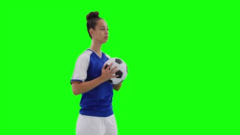 Video-of-caucasian-female-football-player-holding-football-and-copy-space-on-green-screen