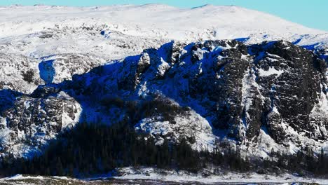 Rocky-Mountains-Covered-In-Snow-During-Winter-In-Bessaker,-Norway---Aerial-Drone-Shot