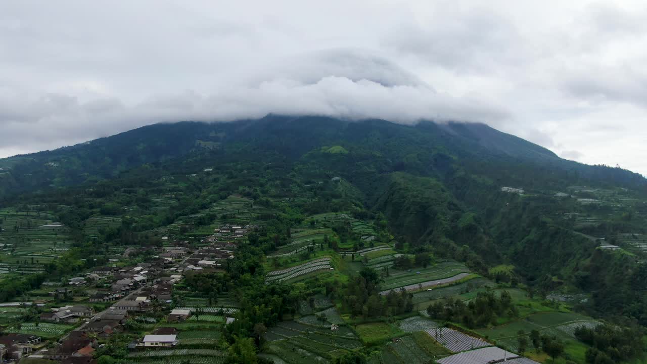 tierras de cultivo javanesas y cumbre del monte merapi cubiertas de nubes, vista aérea