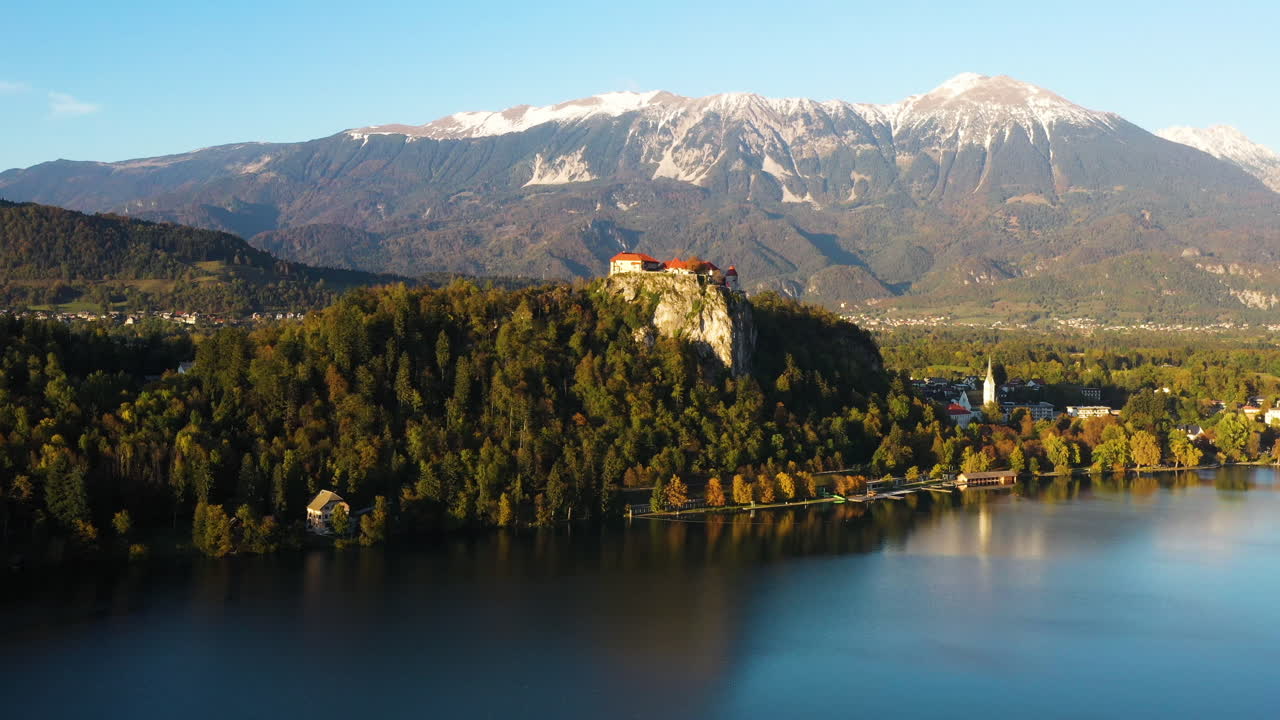 Filmato con drone del Castello di Bled o Blejski grad in Slovenia, con il lago di Bled in primo piano e le Alpi Caravanche in lontananza.