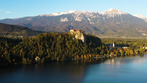 drone footage of bled castle or blejski grad in slovenia, with lake bled in the foreground and the karawanks mountains in the distance