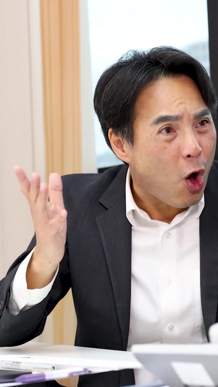 プロフェッショナルな議論中に強い驚きと不信感を表明するビジネスマンの縦長のクローズアップ