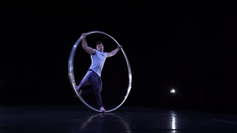 circus artist shows concentration and balance while spinning on a cyr wheel