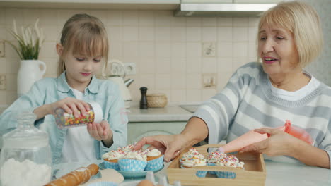 grandmother and granddaughter baking cupcakes together