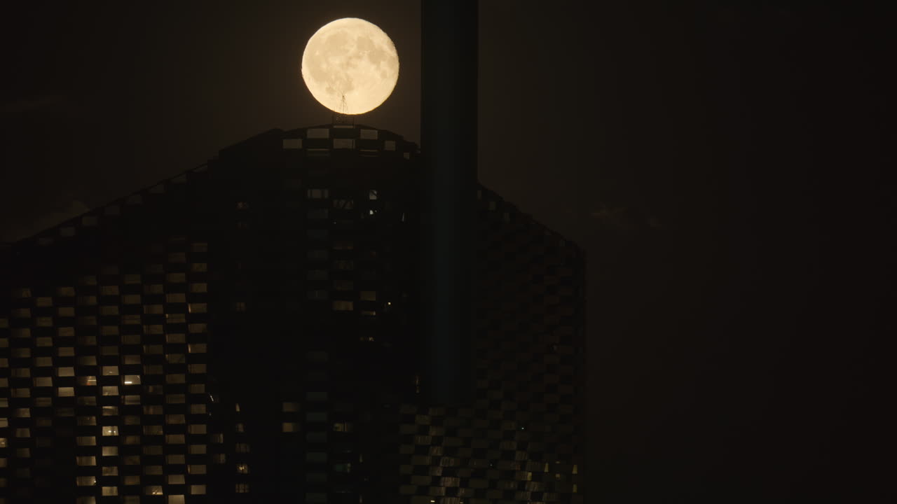 Luna piena che sorge sull'edificio Copenhill creando un'atmosfera misteriosa di notte. Copenaghen, Danimarca