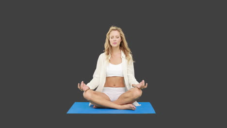 una rubia muy en forma haciendo yoga.
