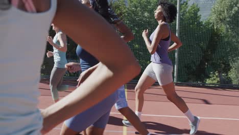 happy diverse female basketball team training on sunny court, in slow motion