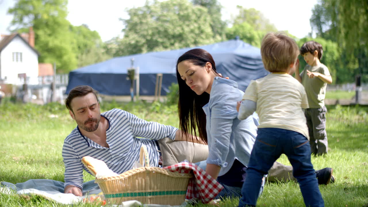 secuencia en cámara lenta de una familia disfrutando de un picnic a orillas del río