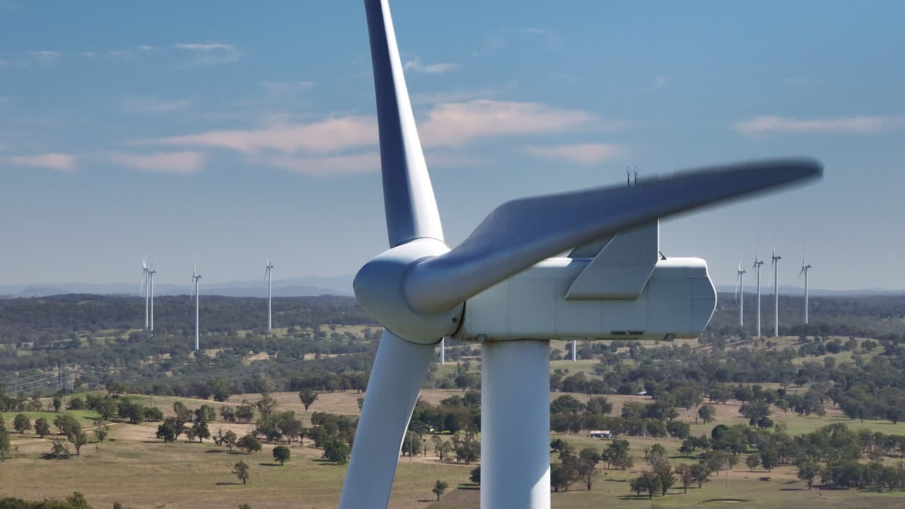 cerca de la hélice de la turbina eólica girando en un día ventoso en australia, con vistas al campo rural 4k drone de cámara lenta