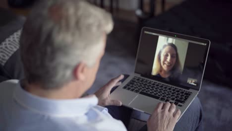 Mid-adult-man-using-laptop-for-distance-chat-with-wife