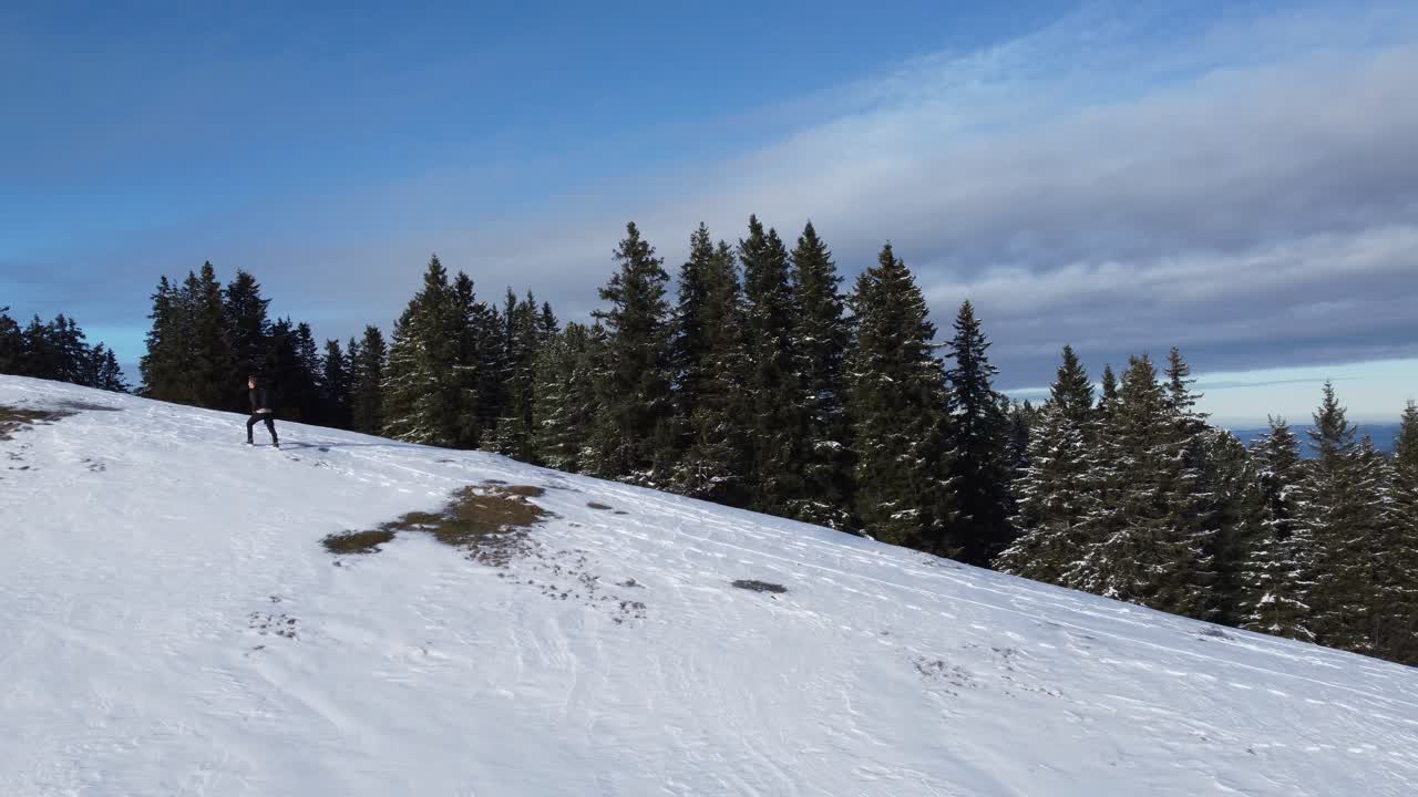siguiendo a un hombre escalando una montaña nevada