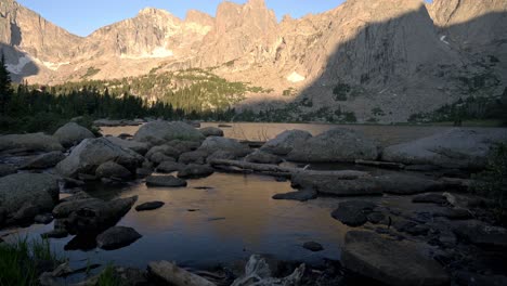 tilt up across stunning natural beauty of cirque of the towers, wyoming with mountain reflection in water