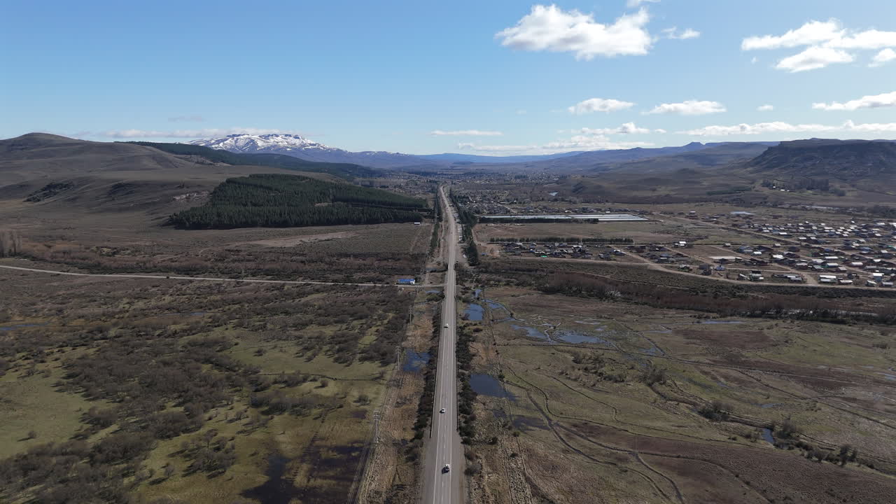 Junin de los Andres in Patagonia, arriving to the town above the route 234, slow motion drone flying forward footage above traffic
