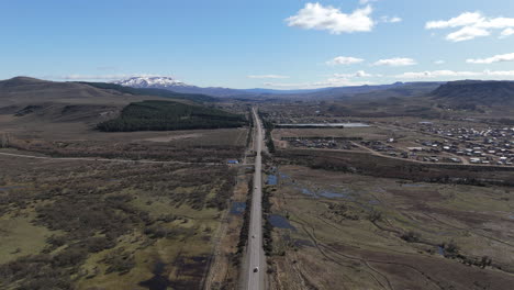 junin de los andres in patagonia, arriving to the town above the route 234, slow motion drone flying forward footage above traffic