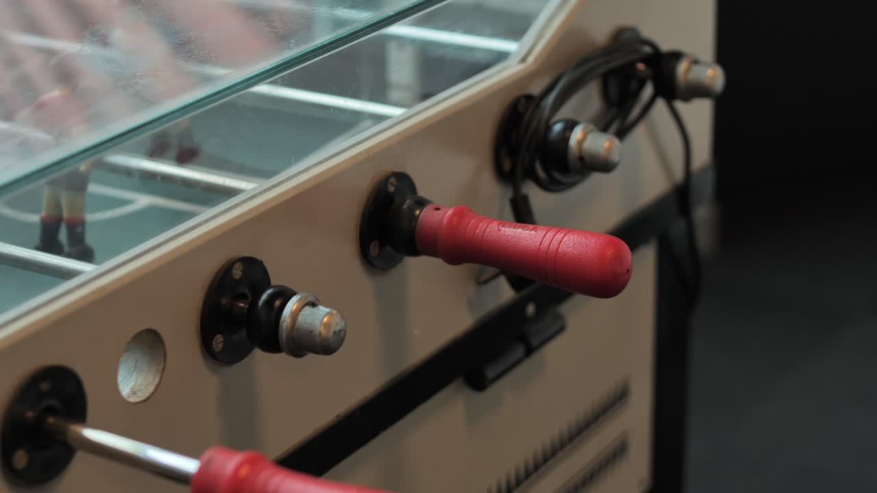 Detailed view of foosball table handles during slow sliding motion - 4K.