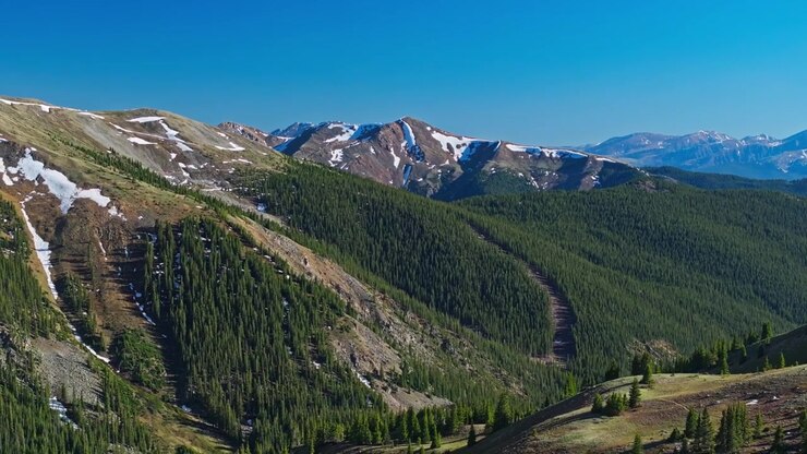 Valle alpina verde incorniciata da montagne aspre al Loveland Pass, sfondo testurizzato ripreso con teleobiettivo da drone.