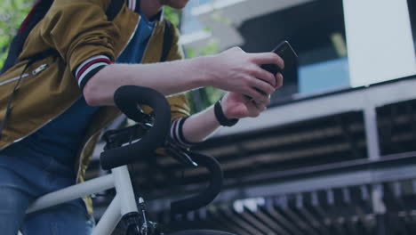 using smartphone, person in casual jacket leaning on bicycle outdoors in animation