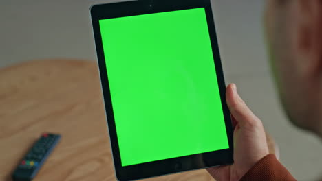 man holding green screen tablet at house closeup. unknown freelancer working