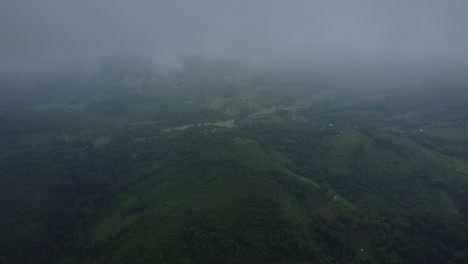 una manta de densa niebla blanca casi cubre el paisaje verde de abajo