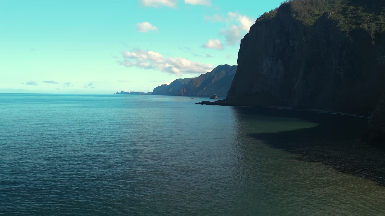 Aerial exploration highlighting Miradouro do Guindaste viewpoint in Madeira, vivid ocean waves and rugged shoreline highlighted by radiant daylight
