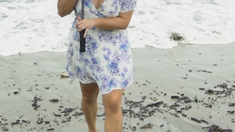 Mujer-Caminando-Hacia-Cámara-Lenta-En-La-Playa-Bajo-La-Lluvia