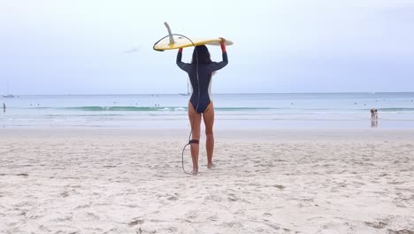woman with surfboard on the beach