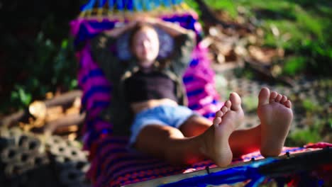 cerca de los pies de la mujer mientras se relaja en una hamaca al aire libre durante la puesta de sol