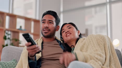 Couple,-watching-tv-and-talking-on-a-home-sofa