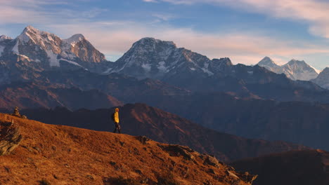 A-male-tourist-trekking,-drone-shot-ridge-with-Nepal-Everest-Mountain-range-PikeyPeak-4K
